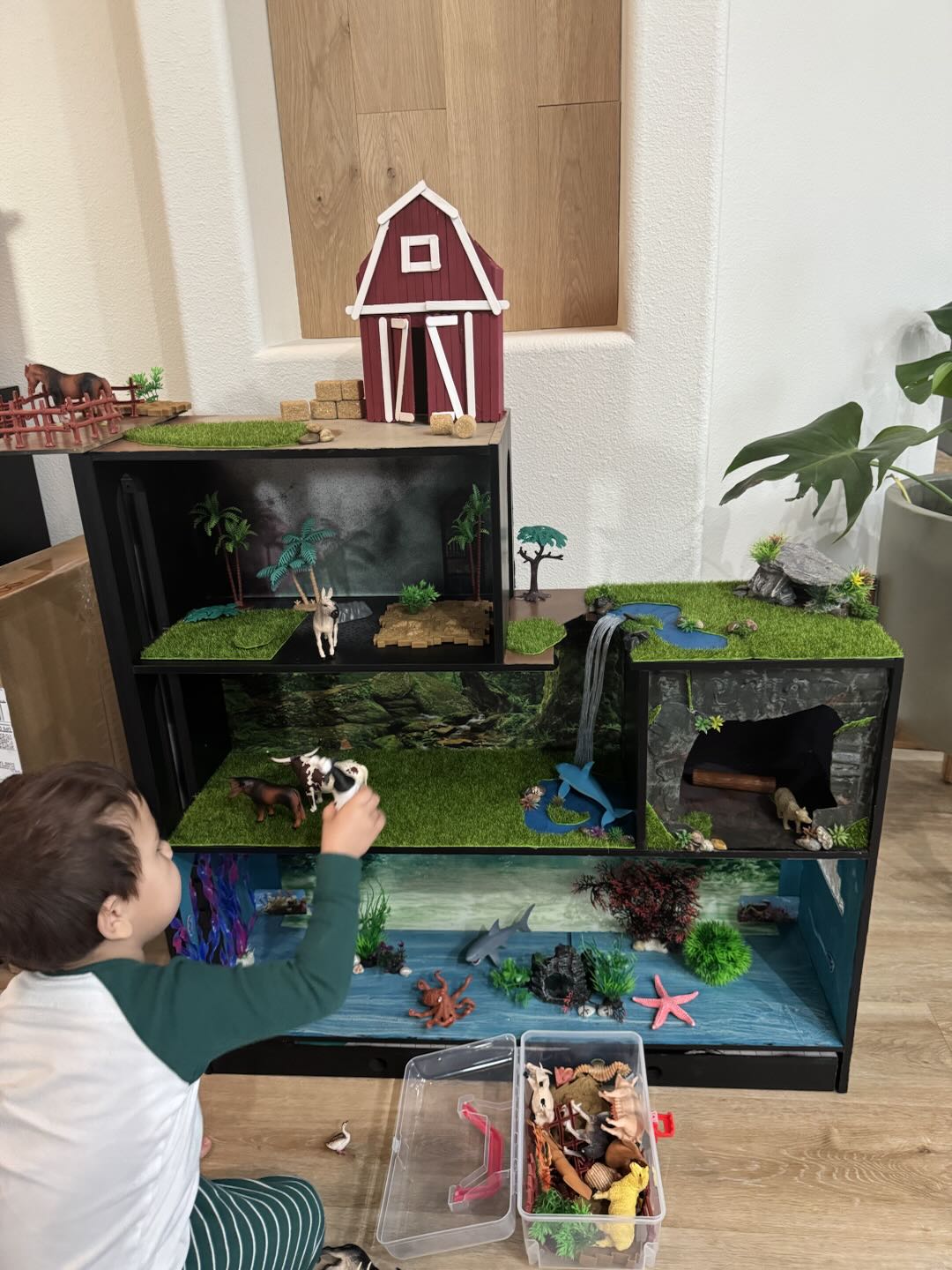 The full multi-level play world viewed from the side, showing the barn, savanna, jungle and ocean levels