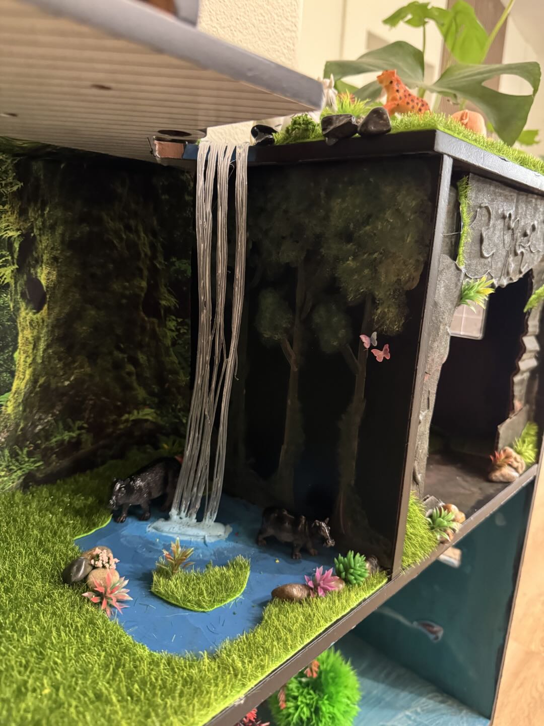 A jungle level with a tumbling waterfall, mossy walls, a deep forest backdrop, and wild boar by a blue pool